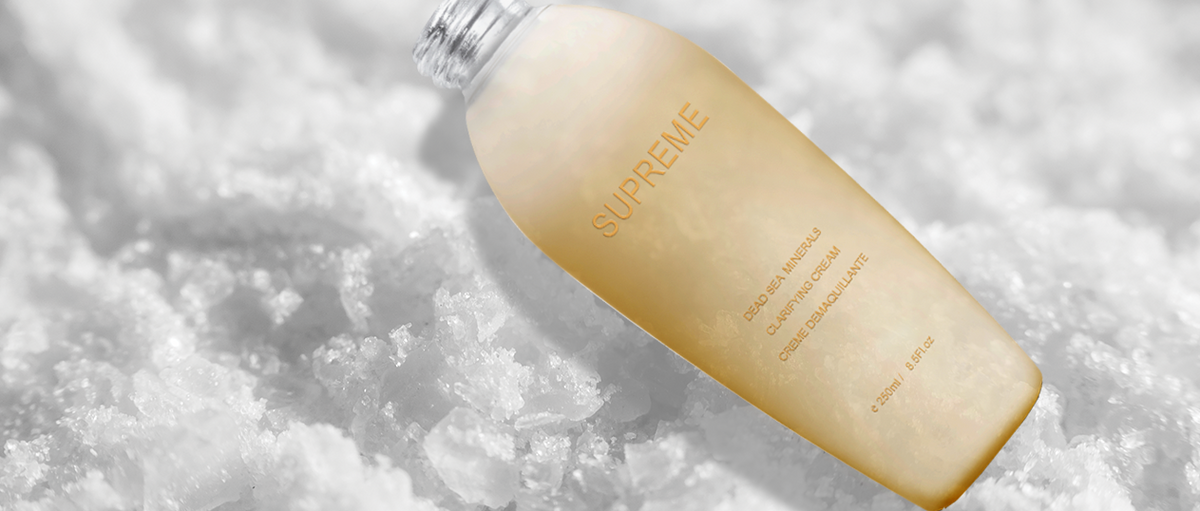 Limpiador Supreme Clarifying Cream de Premier de 250 ml sobre cristales blancos de sal.