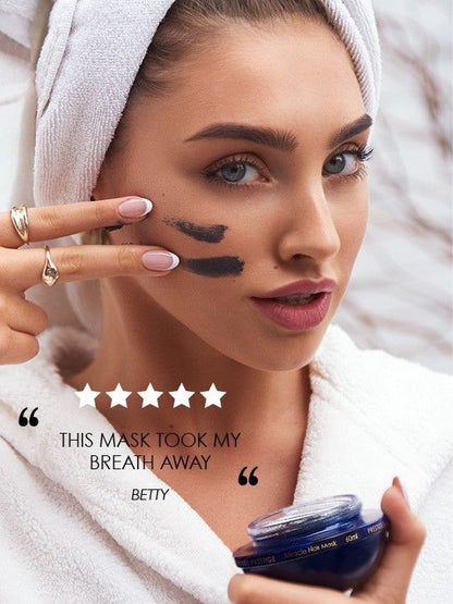 Modelo aplicando mascarilla Milagro Negro de Premier en la mejilla y sosteniendo el tarro azul, con reseña superpuesta.