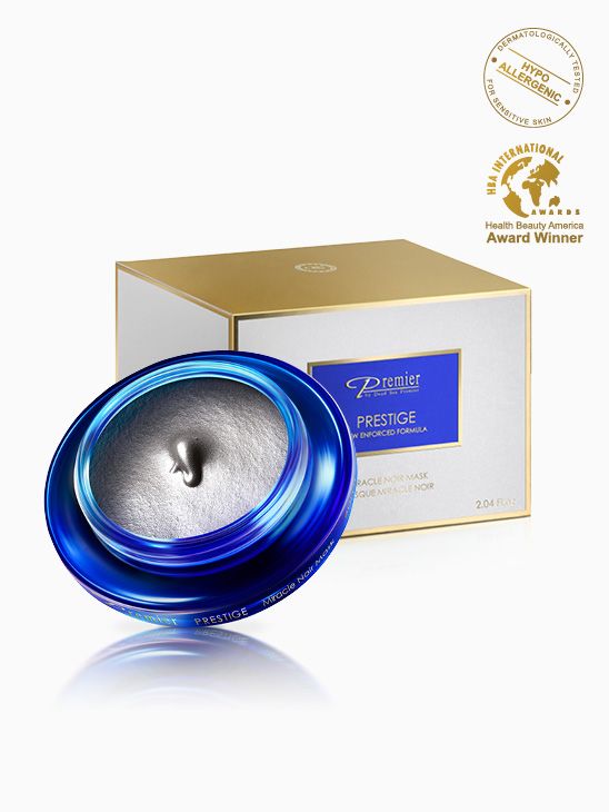 Mascarilla Milagro Negro de Premier Prestige en tarro azul abierto con textura gris y caja blanca y dorada.